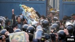 Protesters remove the crest of the British Embassy in front of the Gholhak residential compound of the British Embassy in north Tehran in November 2011.