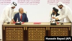 Угоду підписали представник США з мирного врегулювання Залмай Халілзад (ліворуч) та політичний лідер «Талібану» Абдул-Гані Барадар в столиці Катару Досі 29 лютого 2020 року