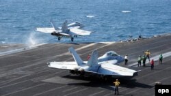 Sailors in the Arabian Sea direct and launch fighters from the flight deck of the aircraft carrier "U.S.S. George H.W. Bush," which has been supporting air strike operations against Islamic State.