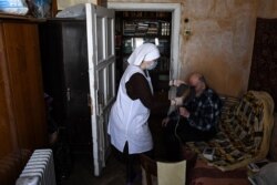 A nurse tends to a man at home in Moscow on May 25 amid the coronavirus outbreak.