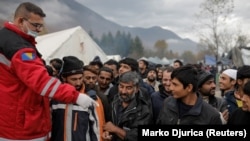 Migrants queue for free shoes delivery inside Vucjak camp near Bihac on November 15.