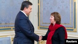 Ukrainian President Viktor Yanukovych (left) shakes hands with EU foreign-policy chief Catherine Ashton during a meeting in Kyiv on January 29.