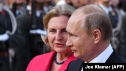 Russian President Vladimir Putin (right) and Austrian Foreign Minister Karin Kneissl take part in a wreath laying ceremony at the Soviet World War II memorial in Vienna on June 5.