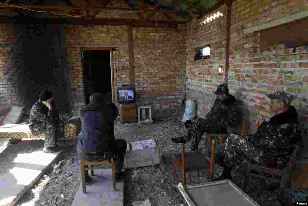 Ukrainian servicemen watch a TV broadcast of Russian President Vladimir Putin signing a law that ratifies a treaty making Crimea part of Russia, at a Ukrainian military base in the Crimean town of Belbek on March 21. (Reuters//Vasily Fedosenko)&nbsp;