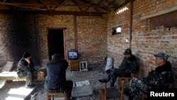 Belbek's Ukrainian servicemen watch a TV broadcast of Russian President Vladimir Putin signing a law on ratification of a treaty making Crimea part of Russia on March 21.