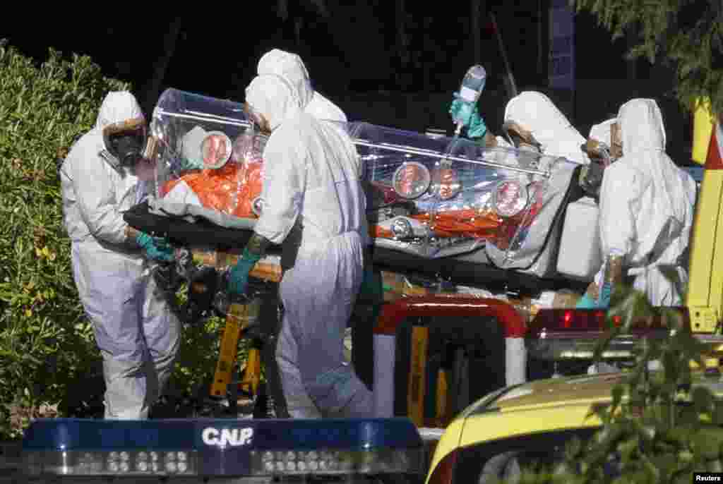 Медики в захисних костюмах евакуюють одного з пацієнтів, імовірно зараженого Ебола в Ліберії, відразу після прибуття в Мадрид. Іспанія. 7 серпня 2014 