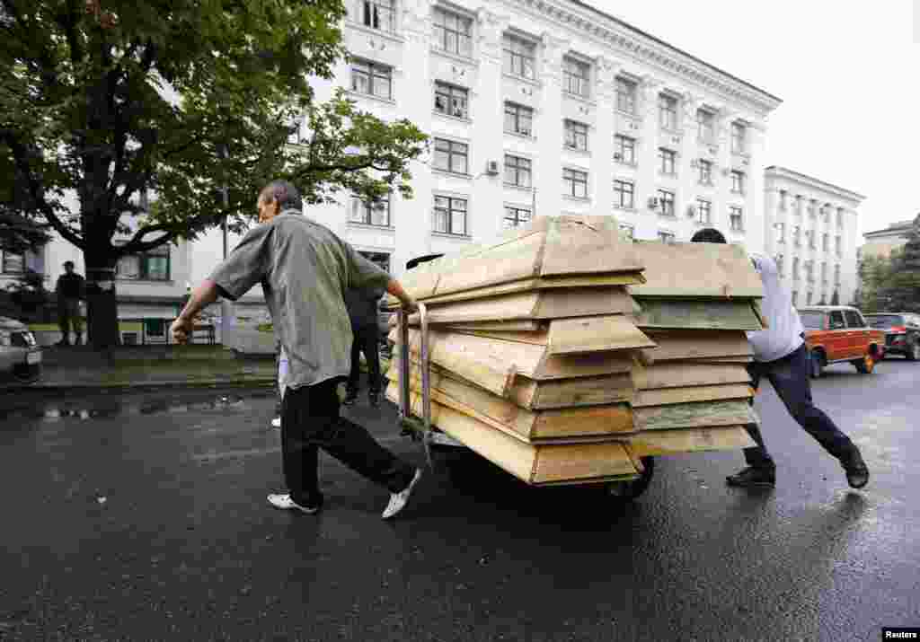 Сепаратисти тягнуть порожні труни для тіл загиблих біля обласного штабу &laquo;ЛНР&raquo; в Луганську, 18 червня 2014 року