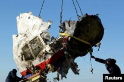 A piece of wreckage from Malaysia Airlines Flight MH17 is loaded for transport to the Netherlands in the village of Hrabove in the Donetsk region on November 20.