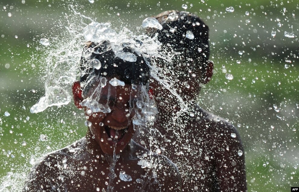 Fëmijët indianë përdorin ujin për t'u freksuar ngritjes së temperaturave në Allahabad.