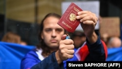 Россиянин сжигает свой паспорт во время акции протеста против вторжения России в Украину. Австралия, Сидней, 26 февраля 2022 года. Иллюстрационное фото
