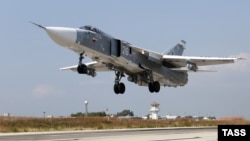 Российский военный реактивный самолет Су-24 вылетает с авиабазы «Хмеймим» рядом Латакией (Сирия), 4 октября 2015 года.