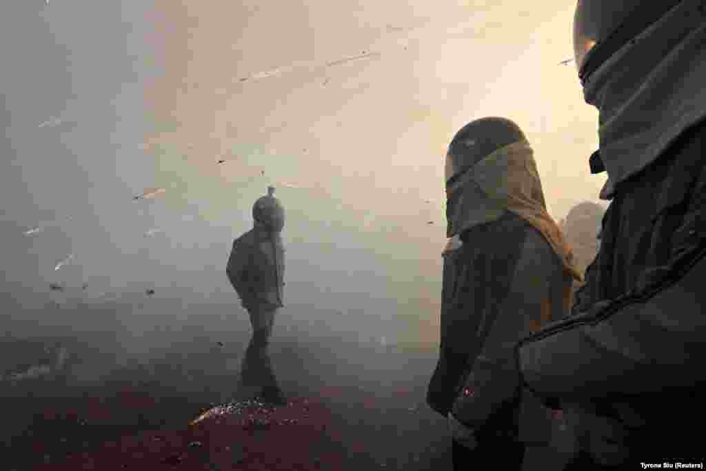 Participants wearing motorcycle helmets get sprayed by firecrackers during the Beehive Firecrackers festival in Tainan, Taiwan. (Reuters/Tyrone Siu)