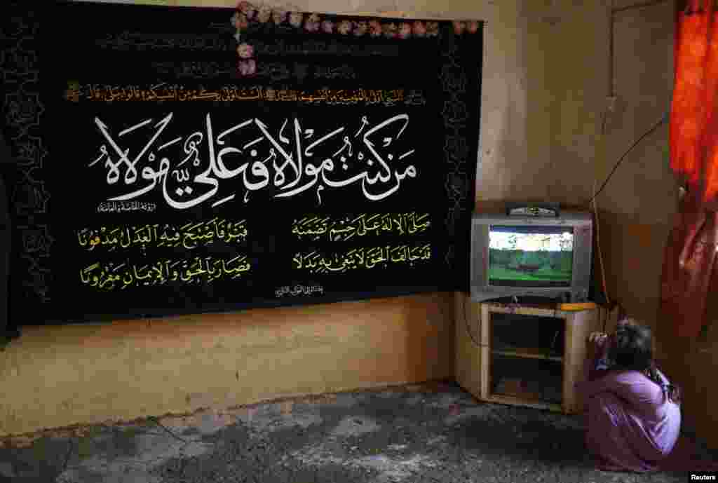 A girl watches television at home in the Al-Fdhiliya district.