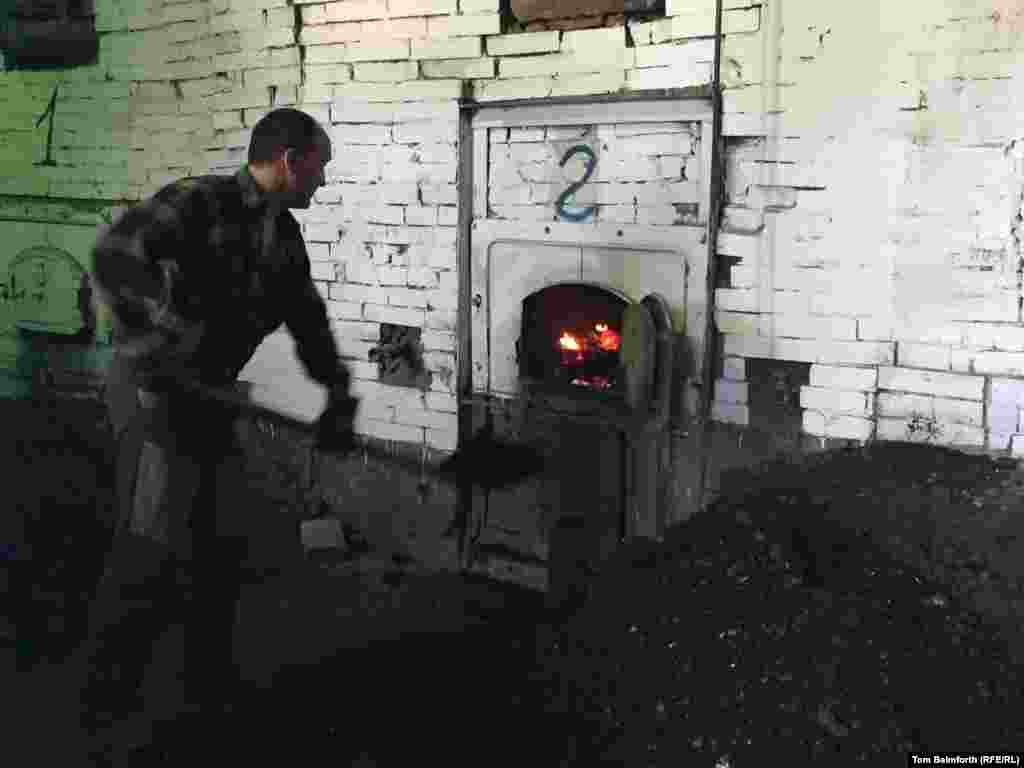 A worker shovels coal in the furnace room. According to the new museum&rsquo;s director, this is where Soviet dissident and veteran rights activist Sergei Kovalyov worked when he served at Perm-36.