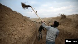 Syrian rebel fighters dig a trench on the fourth day of the truce near the rebel-held besieged city of Douma, in the eastern Damascus suburb of Ghouta, on January 2.