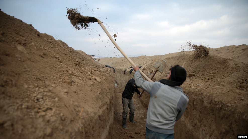 Syrian rebel fighters dig a trench on the fourth day of the truce near the rebel-held besieged city of Douma, in the eastern Damascus suburb of Ghouta, on January 2.