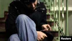 Наркоман робить ін'єкцію героїну на сходовому майданчику в одному з московських будинків. Листопад 2010 року