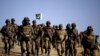 Pakistani troops walk on a hilltop post near Ladha, a town in the tribal region of South Waziristan in May 2011