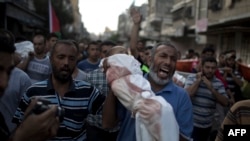 A Palestinian man shouts as he carries the body of 1-year-old baby Noha Mesleh, who died of wounds sustained after a UN school in Beit Hanun was hit by an Israeli tank shell, during her funeral in Beit Lahia in the Gaza Strip on July 25.