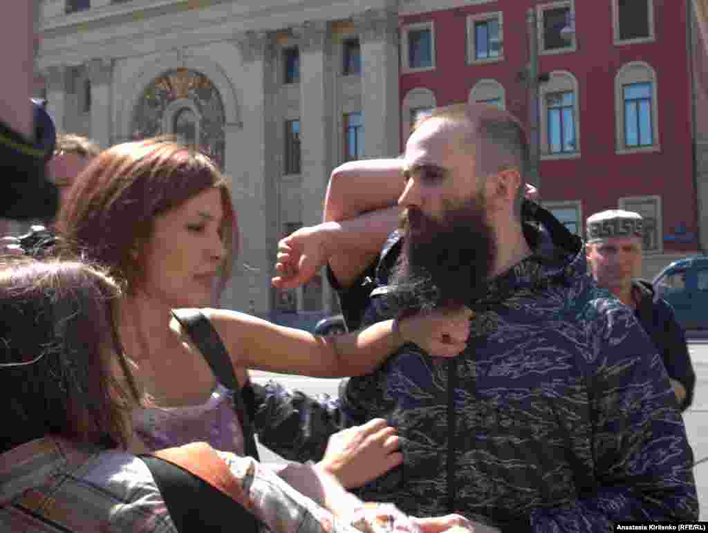 A member of the Russian art collective Voina tries to silence a man yelling, &quot;Moscow without gays!&quot;