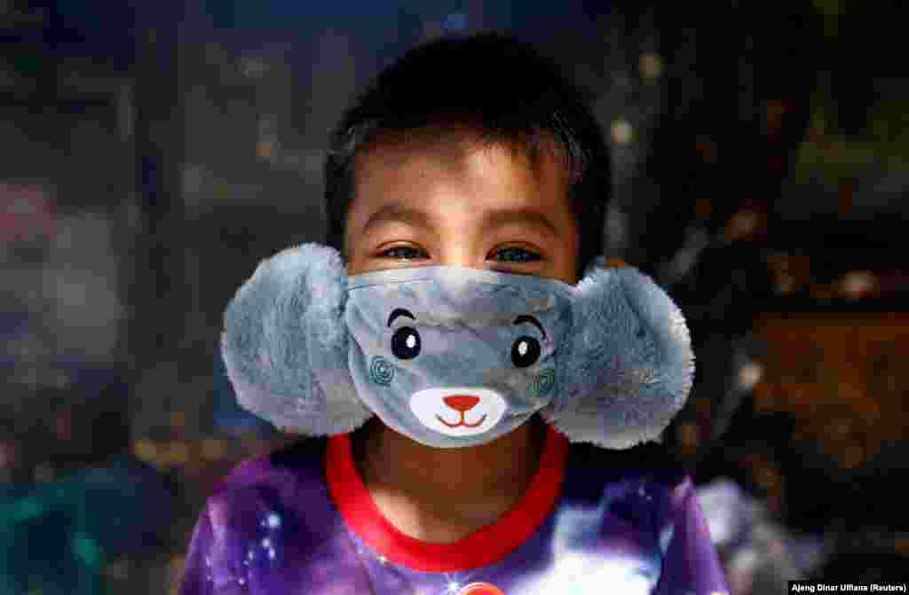 Восьмилетний Панджи из Джакарты (Индонезия) носит маску в виде зверушки, чтобы помочь предотвратить распространение коронавируса, 2 апреля