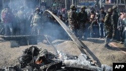 Indian soldiers and Kashmiri onlookers stand near the remains of an Indian Air Force aircraft after it crashed in Budgam district on February 27.