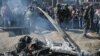 Indian soldiers and Kashmiri onlookers stand near the remains of an Indian Air Force aircraft after it crashed in Budgam district on February 27.