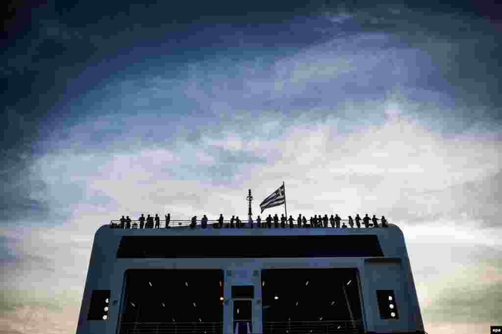 Refugees and migrants are seen on board a ferry at the port in Mytilini on the Greek island of Lesbos. (epa/Filip Singer)