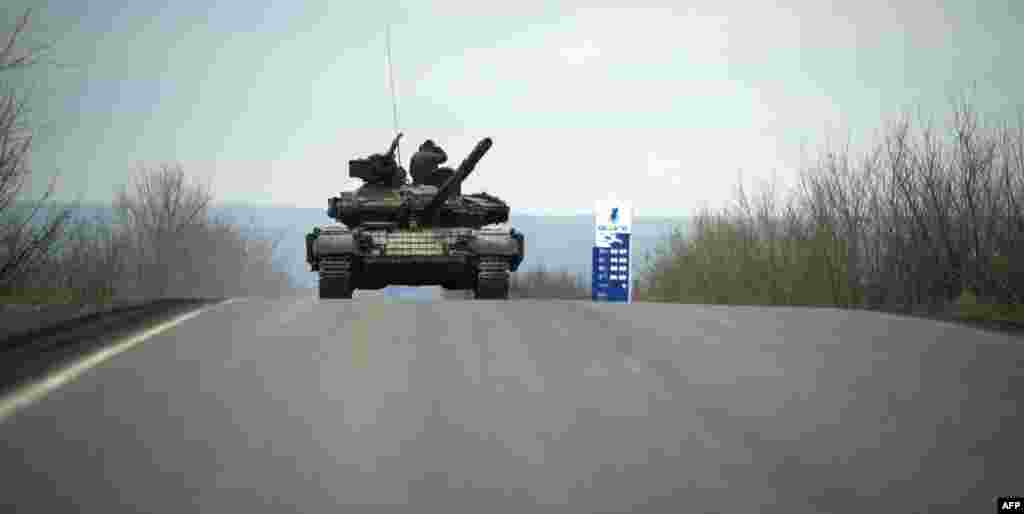 Pro-Russian separatist soldiers stand on their tank as they drive along a road near the village of Kirovske in eastern Ukraine on April 21. (AFP/Odd Anderson)