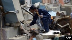 A security official collects evidence at the site of a bomb attack in Karachi, April 24, 2014.