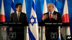 Japan's Prime Minister Shinzo Abe, left, stands as Israeli Prime Minister Benjamin Netanyahu gestures during a press conference at the Prime Minister's office in Jerusalem, Monday, Jan. 19, 2015. (AP Photo/Tsafrir Abayov, Pool)