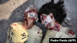 Испанская художница и активистка "Джил Лав" и мексиканская активистка Джулия Клуг выступают во время протеста против убийства женщин в Мехико 27 февраля 2017 года