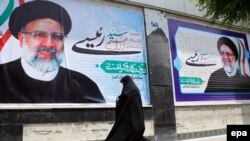 An Iranian woman in the city of Karaj walks past election posters for presidential candidate Ebrahim Raisi four years ago. Raisi lost his bid for the presidency in 2017, losing out to current incumbent Hassan Rohani, but he may fare better this time around. 