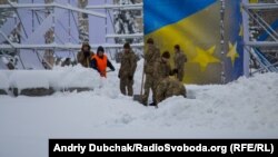 Солдати строкової служби прибирають сніг на майдані Незалежності в центрі Києва, 19 грудня 2017 року