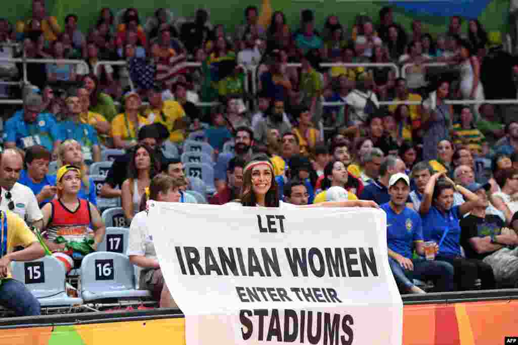 Иранская активистка с плакатом &laquo;Разрешите иранским женщинам пройти на стадионы&raquo; во время волейбольного матча между мужскими командами России и Ирана, 15 августа 2016 года. В Иране женщинам запрещено посещать футбольные и волебольные матчи.&nbsp;
