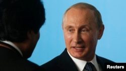Russian President Vladimir Putin talks with Bolivia's President Evo Morales as they attend the official photo session during the sixth BRICS summit and the Union of South American Nations (UNASUR), in Brasilia July 16, 2014. 