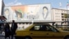 Iranians walk at a street next to the pictures of Iranian late supreme leader Ayatollah Ruhollah Khomeini and current Iranian supreme leader Ayatollah Ali Khamenei, Tehran, Iran, 03 January 2018