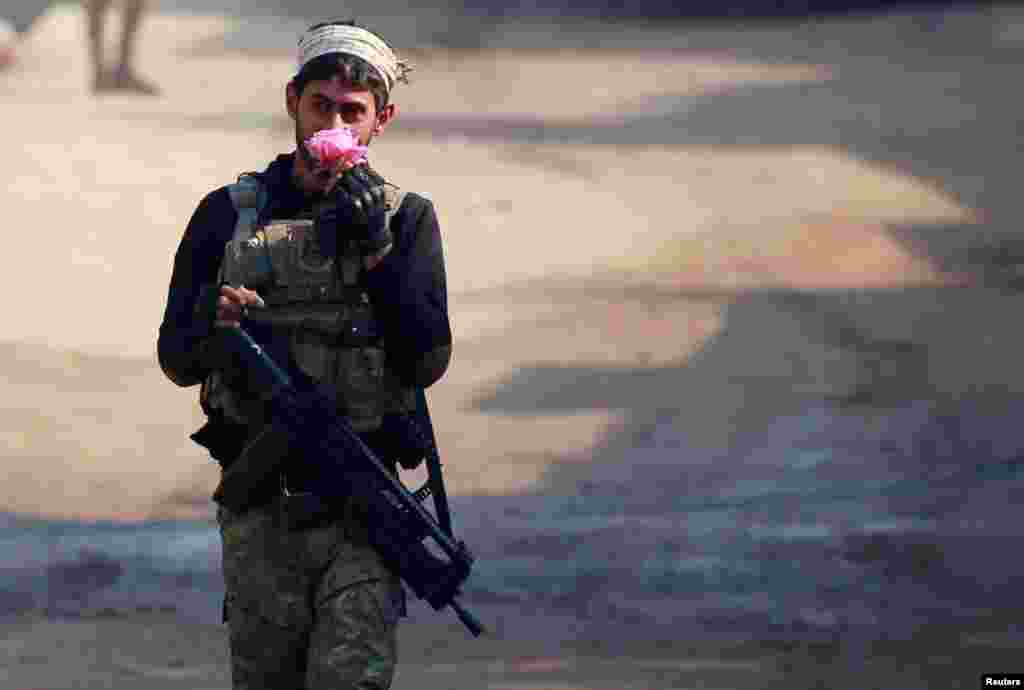 A member of the Iraqi rapid-response forces holds a flower during battle with Islamic State militants in the Mithaq district of eastern Mosul, Iraq, on January 4. (Reuters/Thaier al-Sudani)