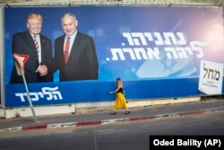 Жінка проходить біля рекламного щита передвиборчої кампанії партії «Лікуд», на якому зображено прем'єр-міністра Ізраїлю Беньяміна Нетаньягу (справа) та президента США Дональда Трампа у Тель-Авіві, Ізраїль, 15 вересня 2019 року