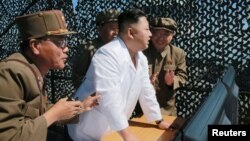 Солтүстік Корея басшысы Ким Чен Ын Сохае ғарыш орталығында сптуникке арналған жаңа зымыран қозғалтқышымен танысып тұр. (Көрнекі сурет.)