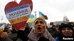 Ukraine -- A woman holds a sign saying "Ukranian ladies are waiting for you on Maidan" as she takes part in a Pro-European integration rally in Independence Square in Kyiv December 15, 2013. 