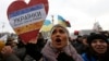 A woman holds a sign saying "Ukranian ladies are waiting for you on Maidan" as she takes part in a pro-EU integration rally in Independence Square.