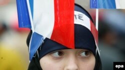 A young Muslim girl in traditional Islamic dress sports French flags and a headband that reads "Fraternity" (file photo)