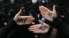 Iranian hardliners protesting against FATF measures. The writings on their palms say "NO TO FATF'.