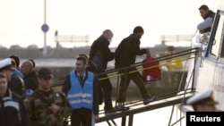 "Frontex" agentliginiň işgäri migrantlary Türkiýäniň baýdagyny göterýän gämä mündürýär, Gresiýanyň Lesbos adasy, 4-nji aprel, 2016