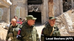 Russian forces patrol damaged buildings in Douma, near the Syrian capital, Damascus. 