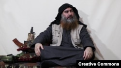 Baghdadi sits with an AKS-74U. After the death of the Islamist fugitive, one of the guns was reportedly recovered from his hideout along with six magazines.