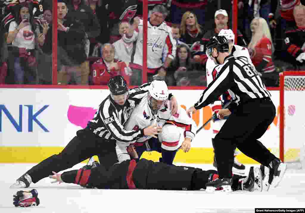 Linesman Scott Cherrey pulls Alex Ovechkin of the Washington Capitals off of Andrei Svechnikov of the Carolina Hurricanes during the first period in game three of the Eastern Conference first round during the 2019 NHL Stanley Cup Playoffs in Raleigh, North Carolina. Svechnikov was knocked out and entered the concussion protocol following the fight. Svechnikov needed to be helped off the ice by his teammates following the brawl. (AFP/Getty Images/Grant Halverson)