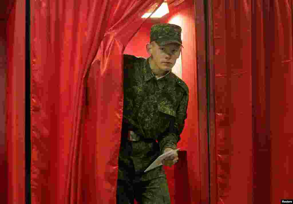 A soldier leaves a voting booth in Minsk.