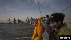 Pakistan -- A Hindu devotee,with his face painted from its sacred mud, prays at the crater of the Chandargup mud volcano during a pilgrimage to the Shri Hinglaj Mata Temple in Pakistan's Balochistan province, 24Apr2011